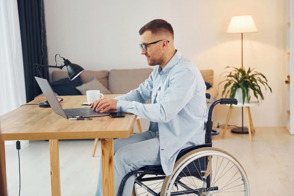 Man in wheelchair working on a laptop